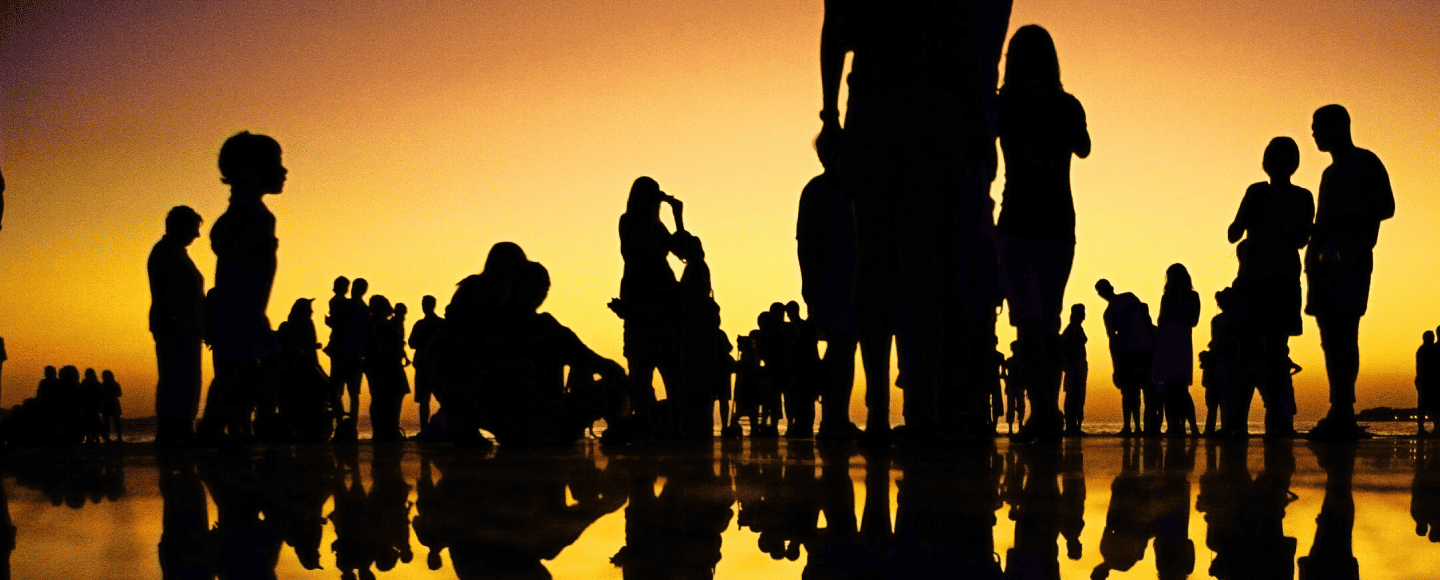 Image of silhouettes people on a beach at sunset