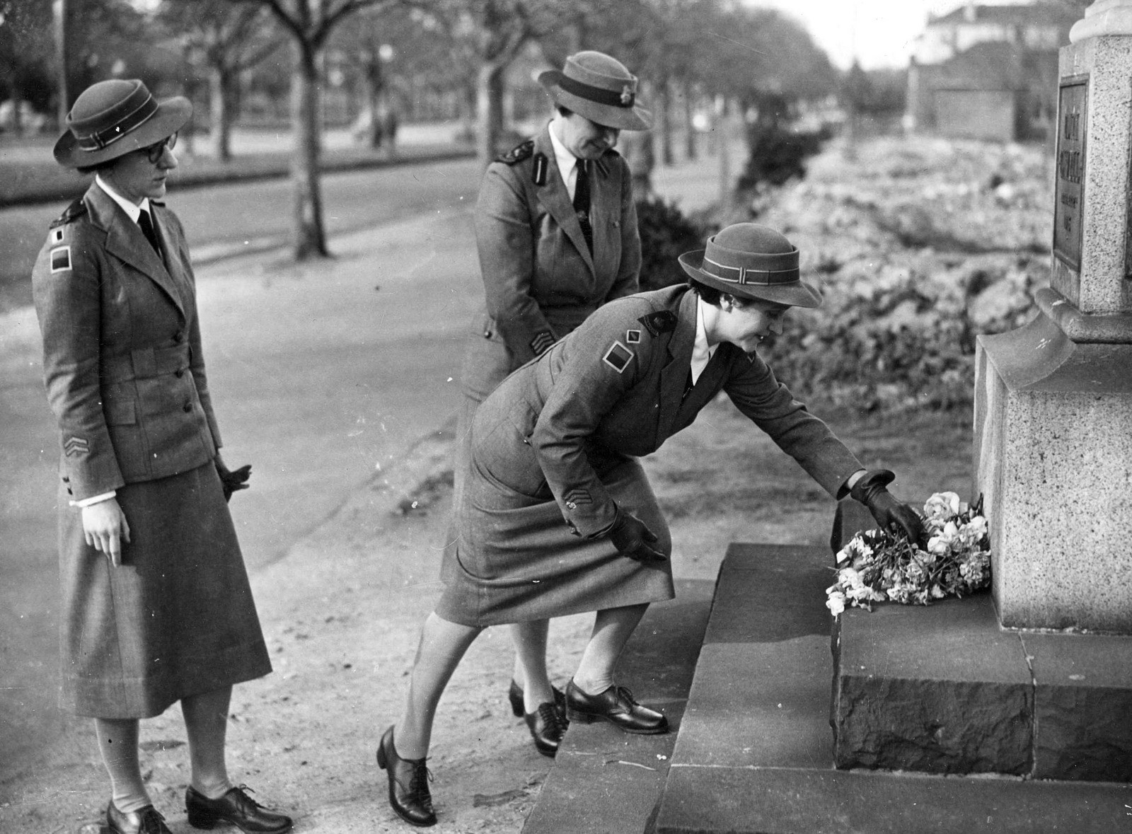 Matron J. Bowe, Sister J. Headberry and Matron A.M. Sage laying flowers on the Edith Cavell Memorial, St. Kilda Road, Melbourne (ca. 1943)