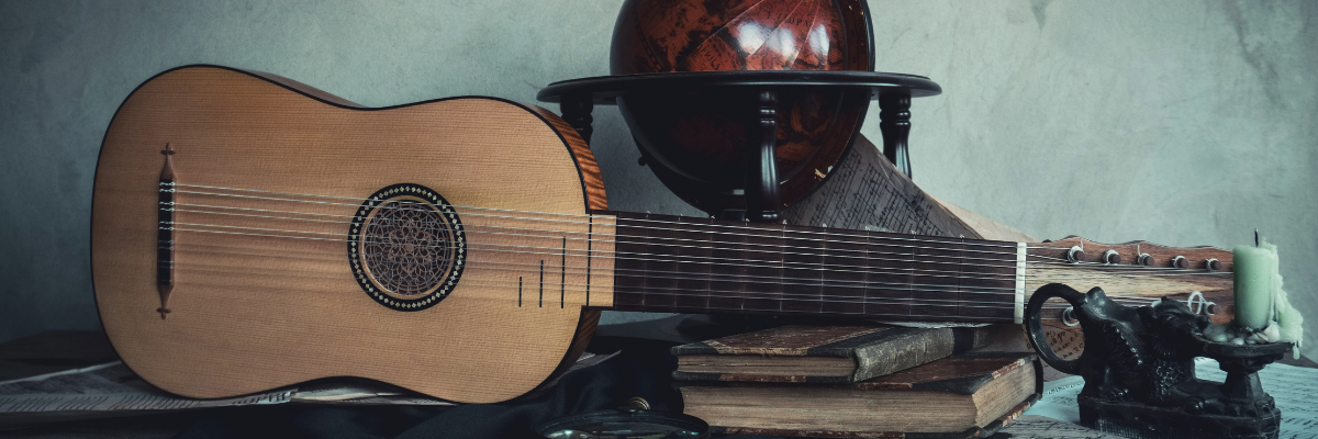 Photo of spanish guitar with ancient books and a globe 