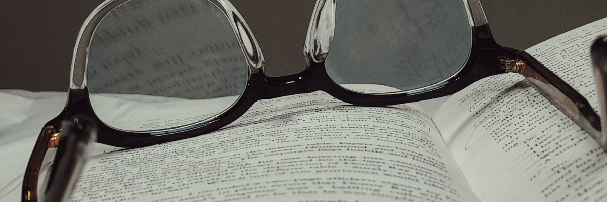 Reading glasses resting on top of an open book 