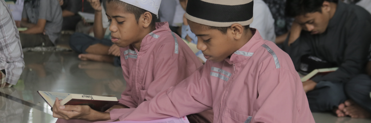Indonesian boys sitting on the floor reading