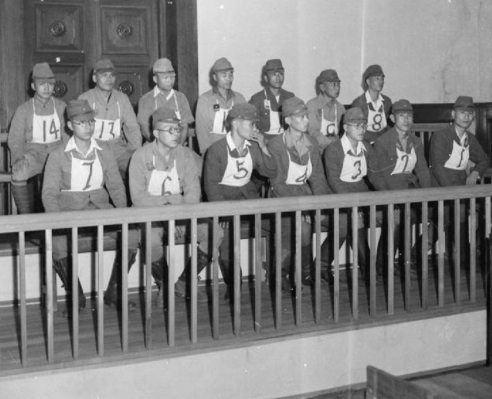 Black and white image of 14 Japanese soldiers on trial for war crimes